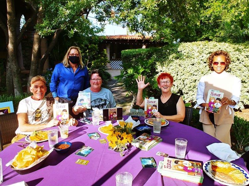 Group showing off children's books: Chosen, Dimes, & Honor